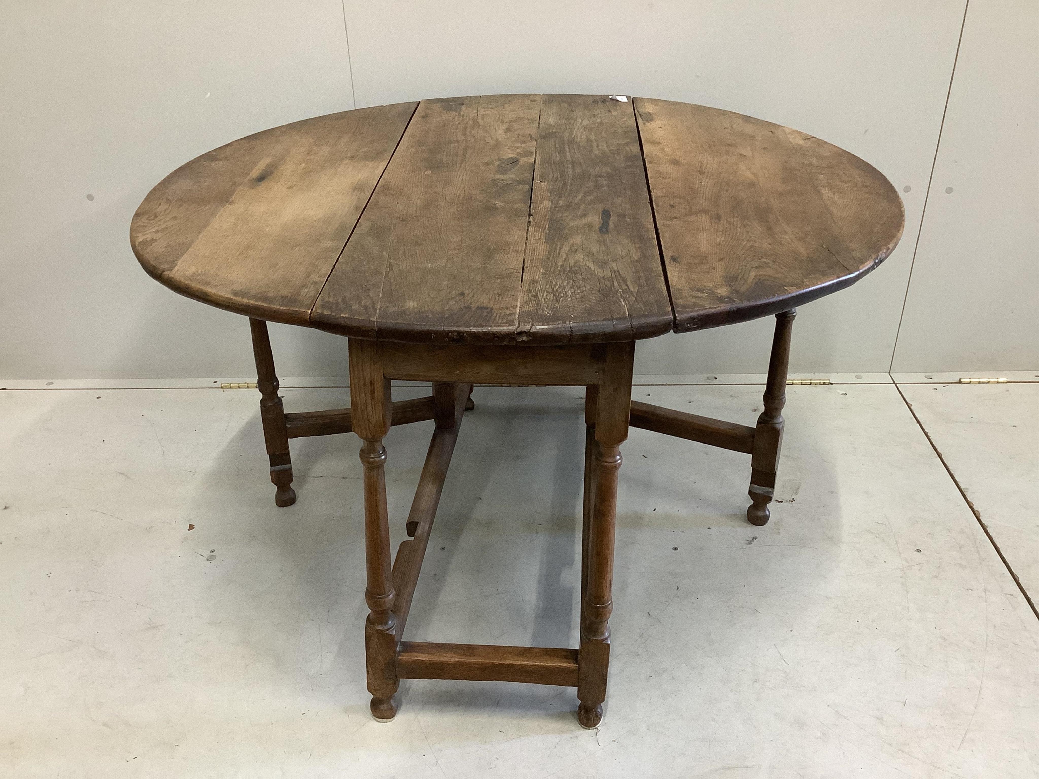 A small late 17th century oak oval topped gate leg table, width 100cm, depth 45cm, height 70cm. Condition - poor to fair